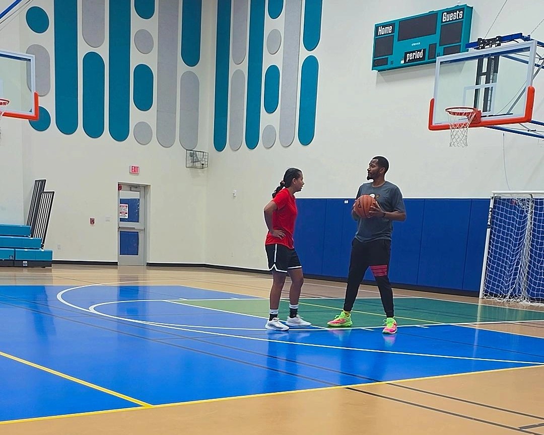 Coach working one-on-one with a player on shooting form